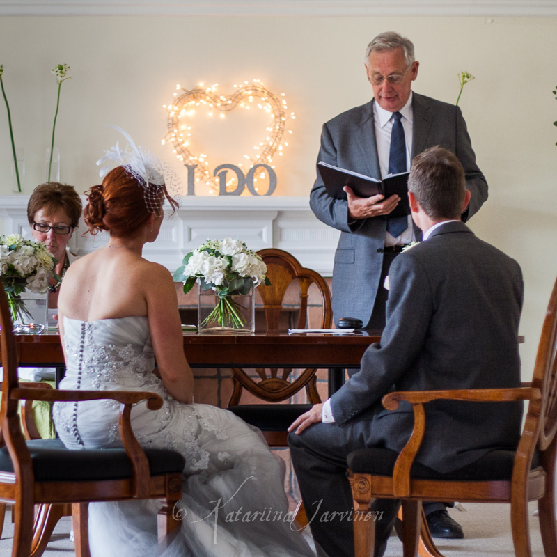 _MG_3371 bride and groom sitting in front of registrar in wedding venue in Seaford, East Sussex